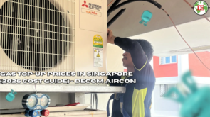 Aircon technician using pressure gauge manifold set to check refrigerant level on outdoor compressor unit in Singapore HDB flat