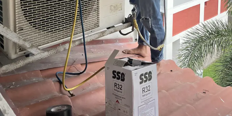 Close-up of manufacturer data sticker on Singapore aircon outdoor compressor unit showing R32 refrigerant type and charge weight in grams