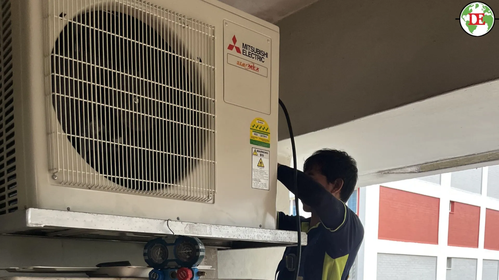 Technician inspecting air conditioner compressor inside outdoor unit Singapore HDB