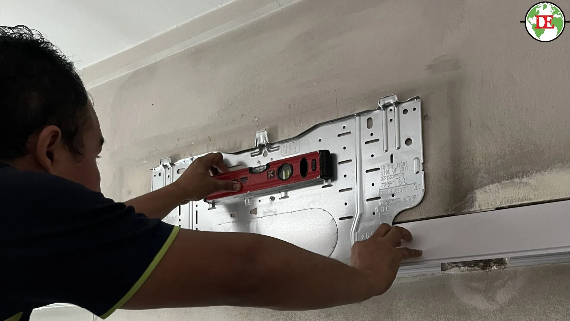 Technician checking aircon drain pipe slope with spirit level Singapore