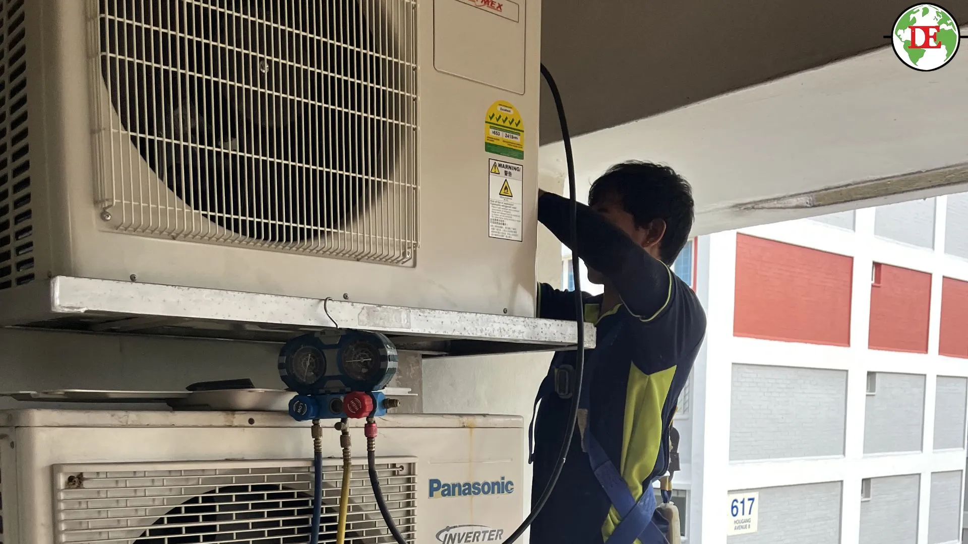 Technician performing refrigerant pump-down before aircon relocation.